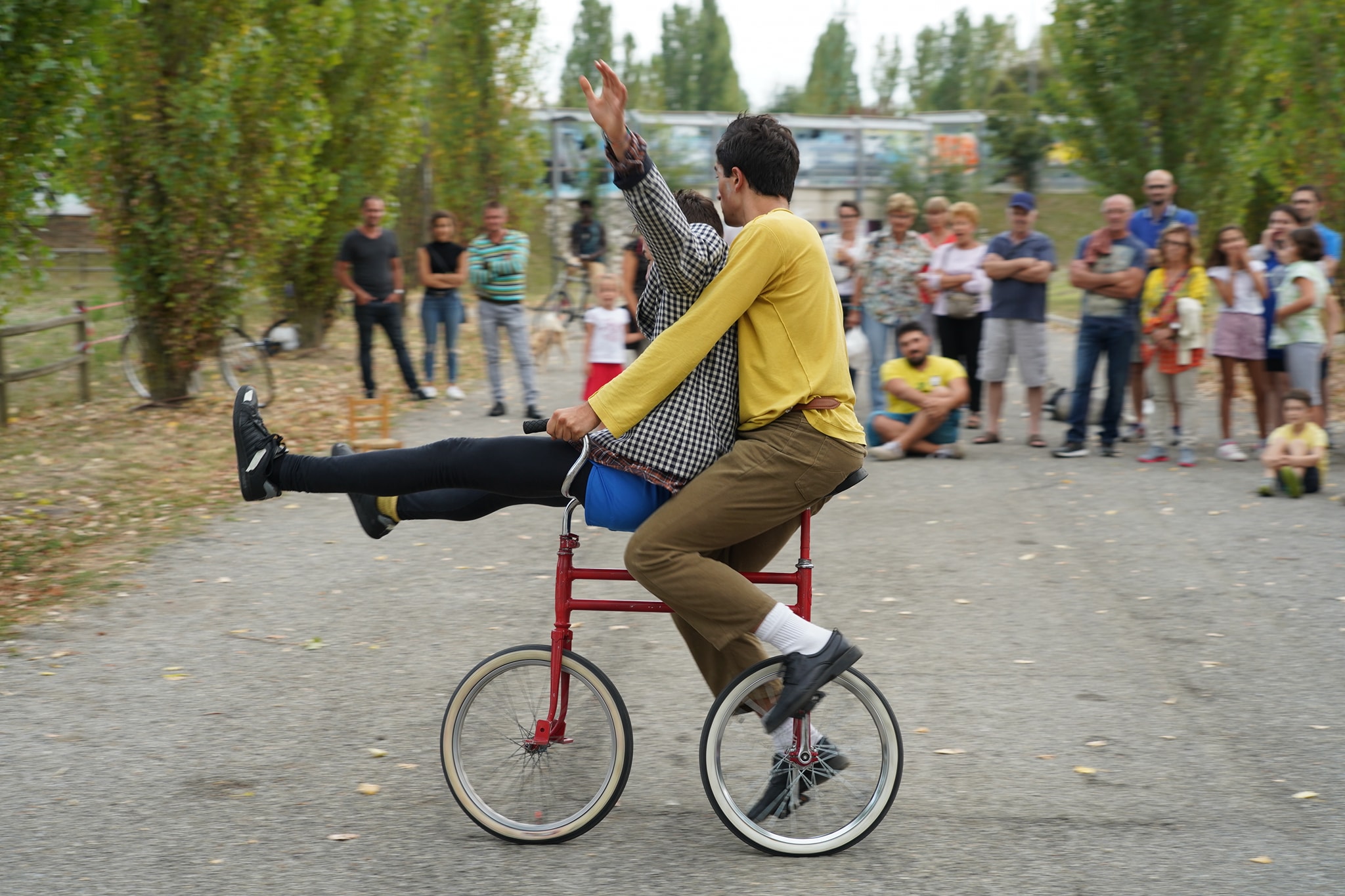 Due clown vanno insieme su una piccola bicicletta rossa.